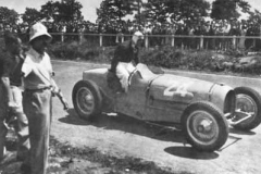 93. Type 59 ACF 23 June 1935 (Montlhery). Car 24, Robert Benoist. Slides down behind the wheel after refitting his cars errant bonnet. (retired later in race)