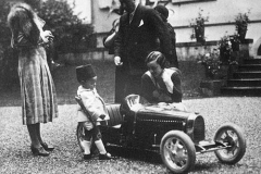 208. Lidia Bugatti and Prince of Morocco looking at a baby Bugatti ?Ettore Bugatti looking on